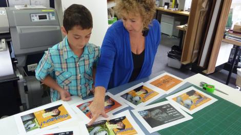 A child and adult looking through a series of advertisements